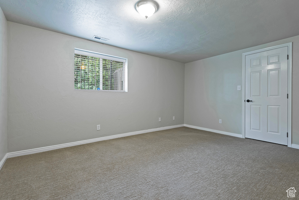 Spare room featuring carpet and a textured ceiling