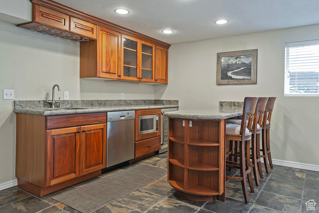 Kitchen with sink, stainless steel appliances, and a breakfast bar