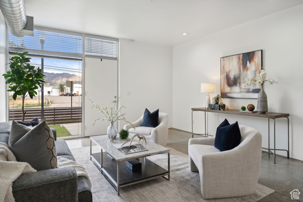 Living room featuring expansive windows, concrete flooring, and a wealth of natural light