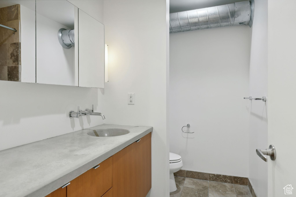 Bathroom with vanity, a shower, and toilet