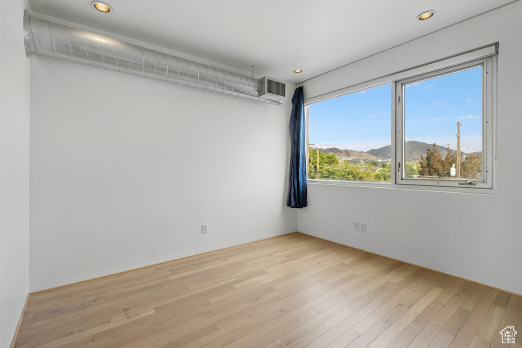 Spare room with a mountain view and light hardwood / wood-style floors