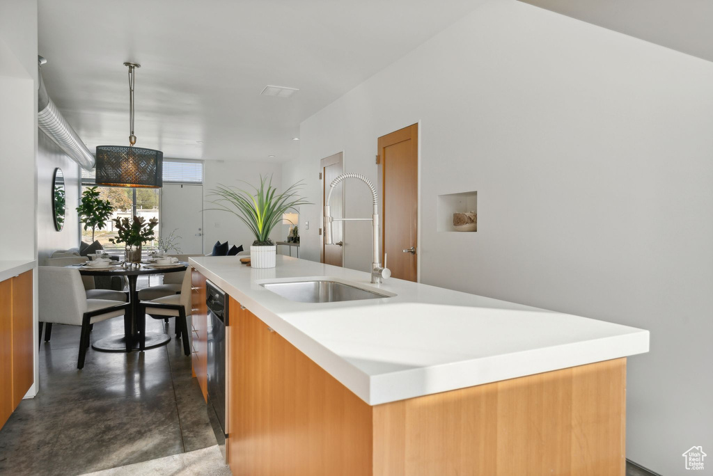 Kitchen with sink, pendant lighting, and a kitchen island with sink