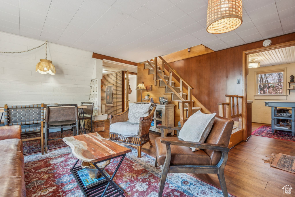 Living room with dark hardwood / wood-style flooring and wooden walls