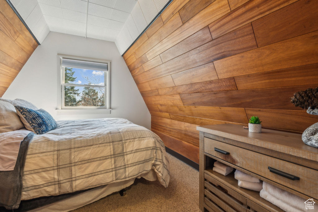 Bedroom with wood walls and carpet flooring