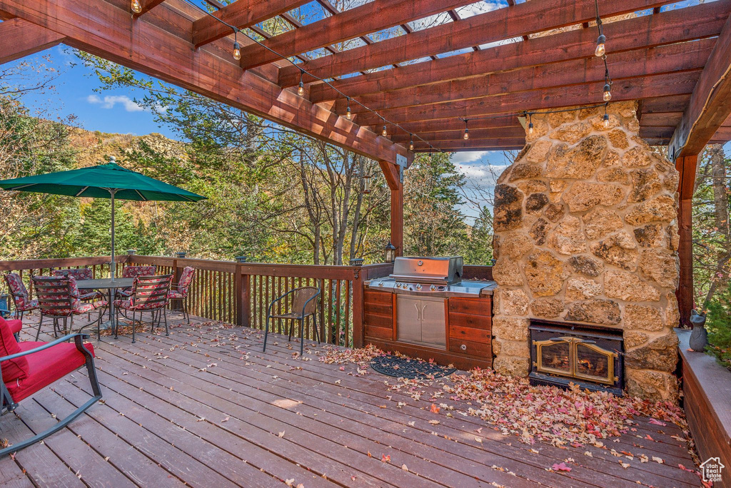 Wooden deck with grilling area, area for grilling, and a pergola