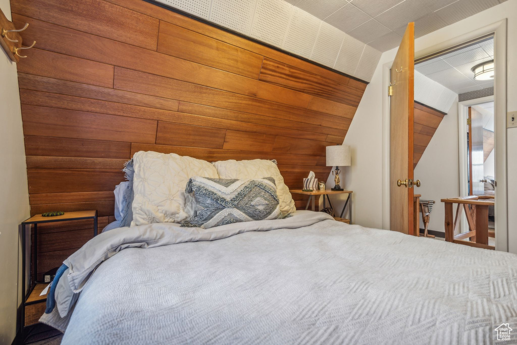 Bedroom featuring a closet and wooden walls