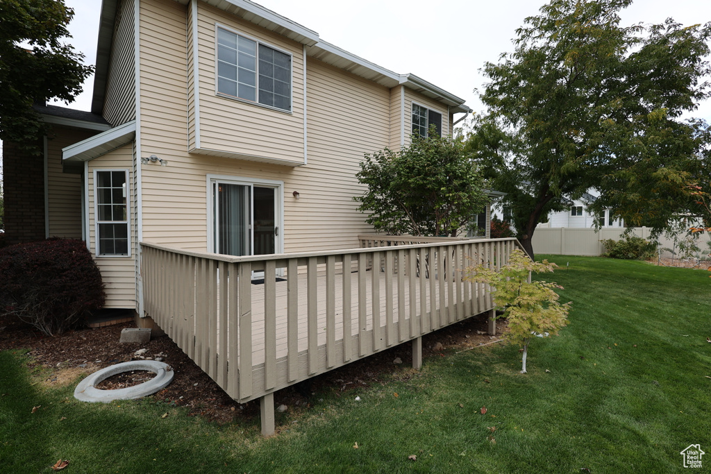 Rear view of property featuring a yard and a wooden deck