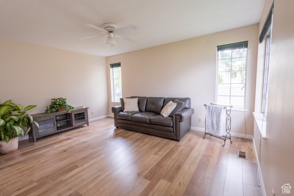 Living room with light wood-type flooring and ceiling fan