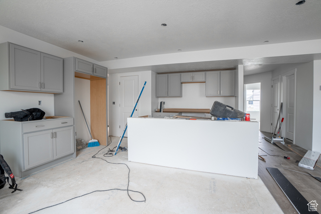 Kitchen with gray cabinetry and a textured ceiling