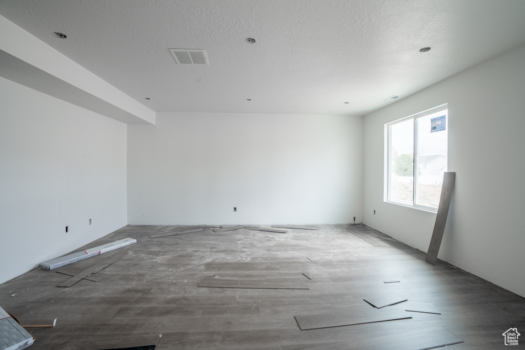 Spare room featuring a textured ceiling and wood-type flooring