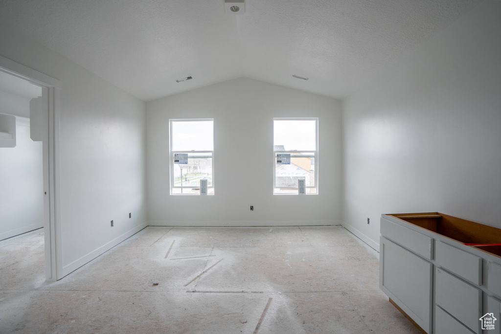 Empty room with lofted ceiling