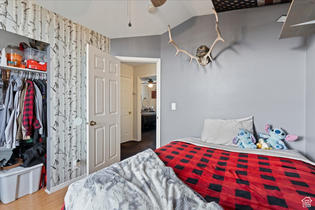 Bedroom featuring a closet, hardwood / wood-style flooring, and lofted ceiling