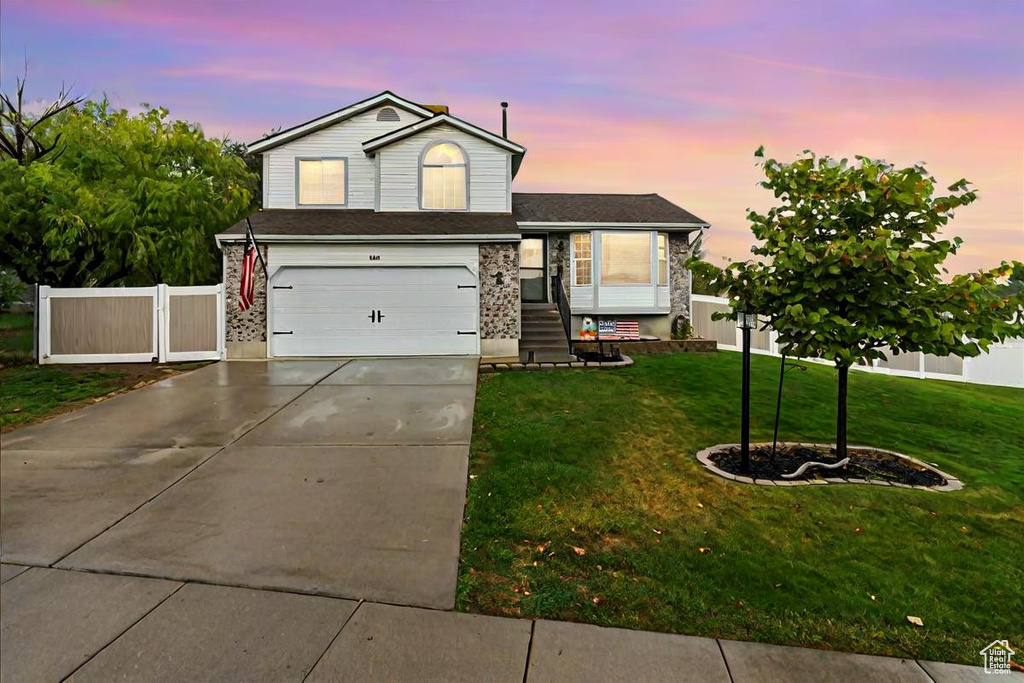 View of front of home featuring a lawn and a garage