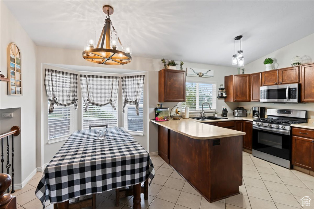 Kitchen featuring lofted ceiling, appliances with stainless steel finishes, sink, and pendant lighting