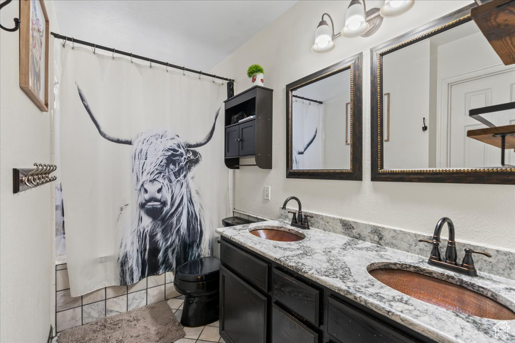 Bathroom featuring vanity, toilet, walk in shower, and tile patterned flooring