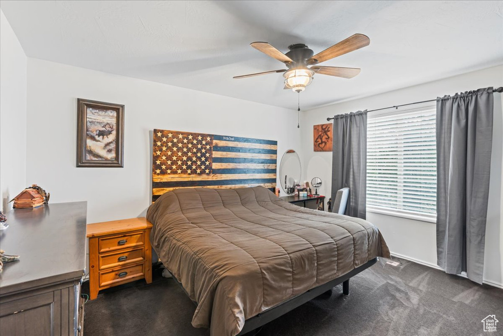 Bedroom with dark carpet and ceiling fan