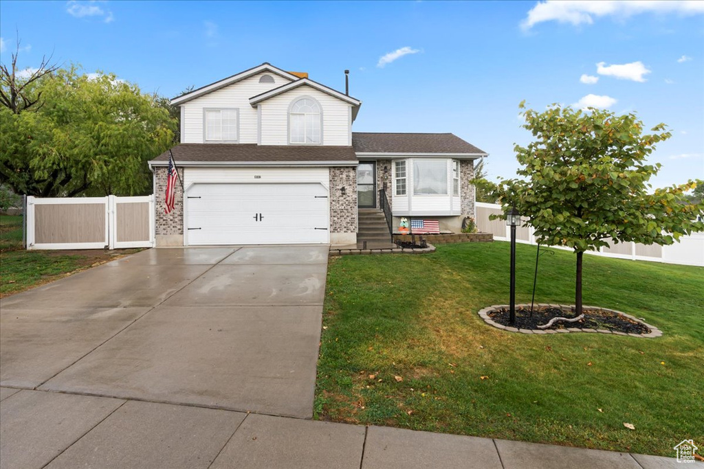 View of front of home featuring a front yard and a garage