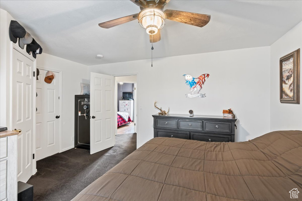 Unfurnished bedroom with ceiling fan and dark carpet