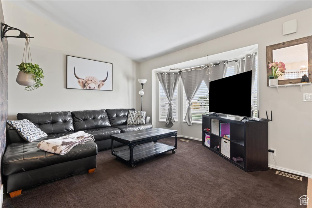 Carpeted living room featuring vaulted ceiling