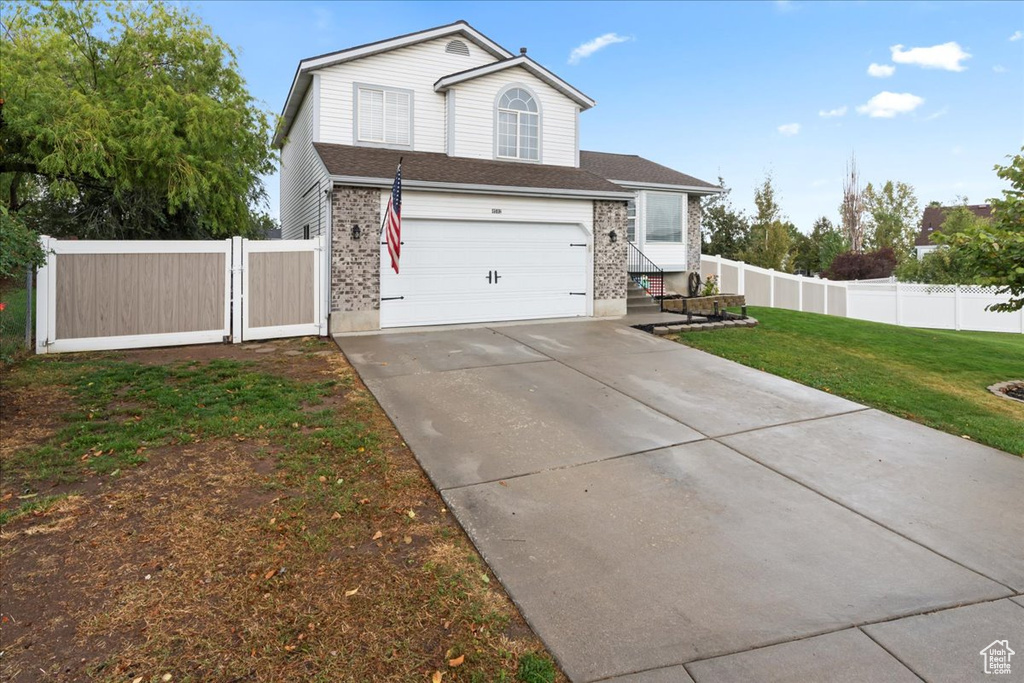 View of front of home with a front lawn and a garage