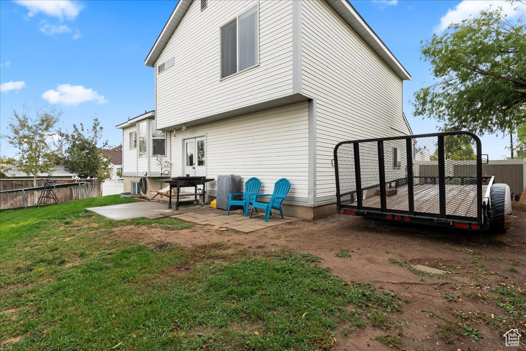 Back of property with a patio and a lawn