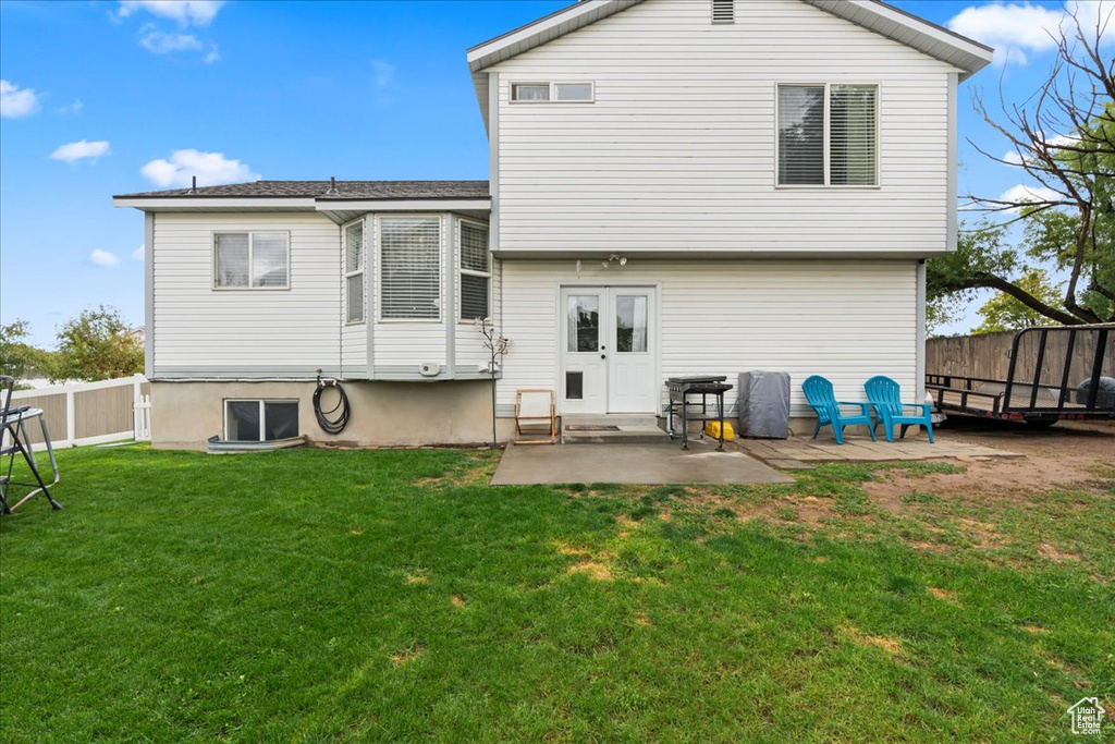 Back of property with a patio and a lawn