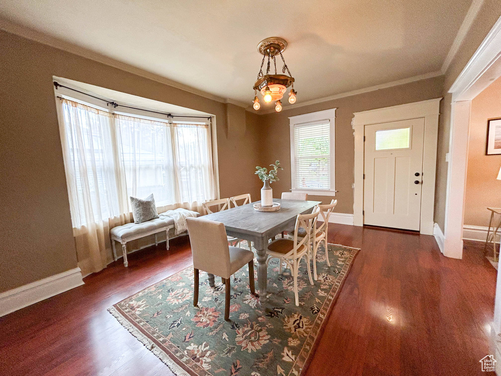 Dining space featuring crown molding, a chandelier, and dark hardwood / wood-style flooring