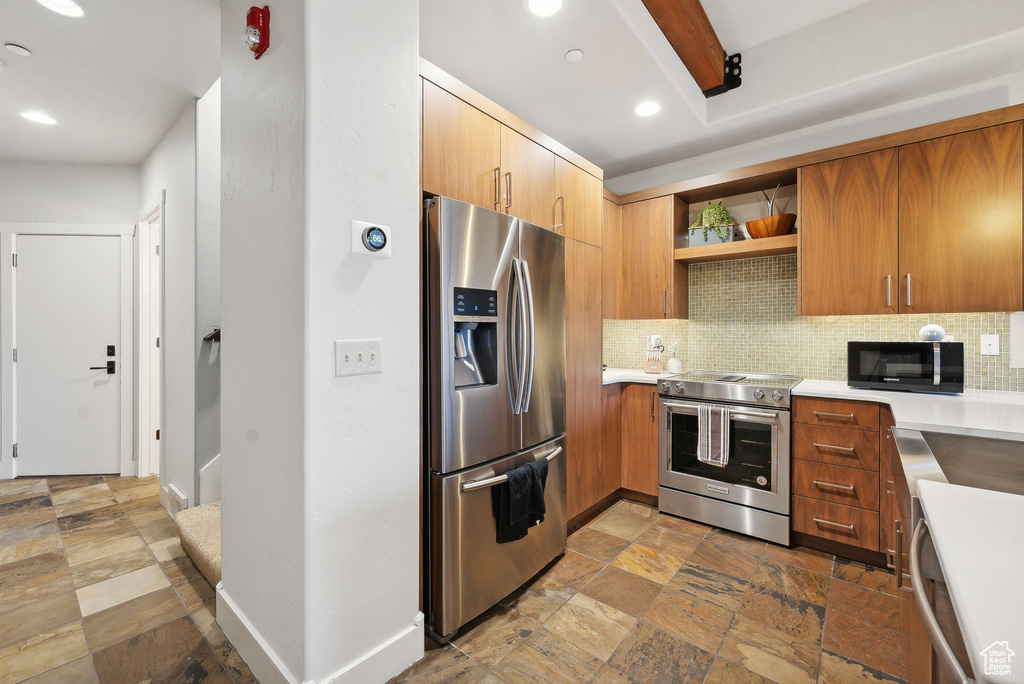 Kitchen with stainless steel appliances and backsplash