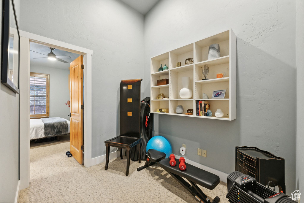 Exercise room featuring light carpet and ceiling fan