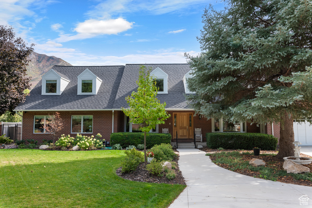 New england style home with a mountain view and a front yard