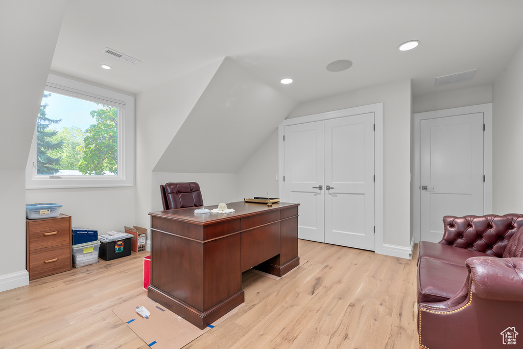 Office area with light hardwood / wood-style flooring and vaulted ceiling