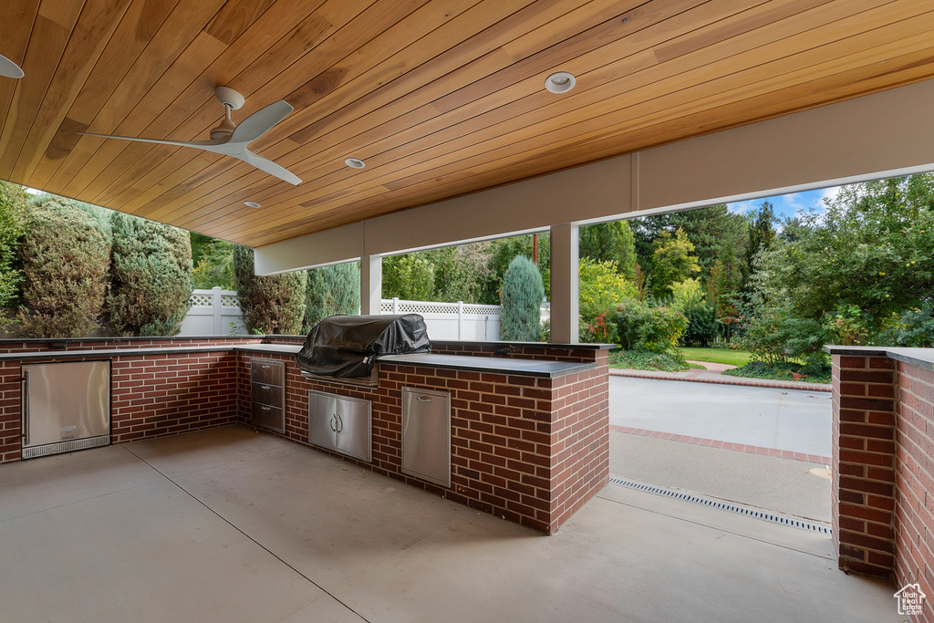 View of patio / terrace with area for grilling, ceiling fan, and a grill