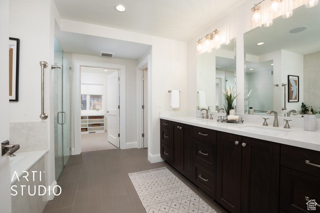 Bathroom featuring tile patterned floors, vanity, and an enclosed shower