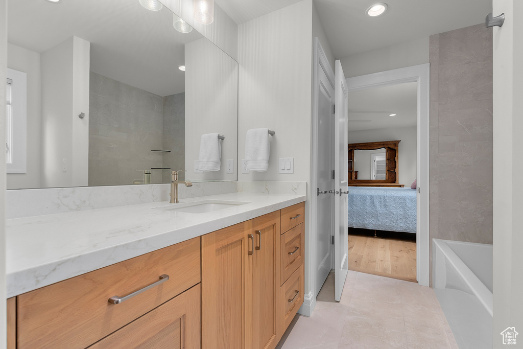 Bathroom featuring vanity, hardwood / wood-style flooring, and a washtub