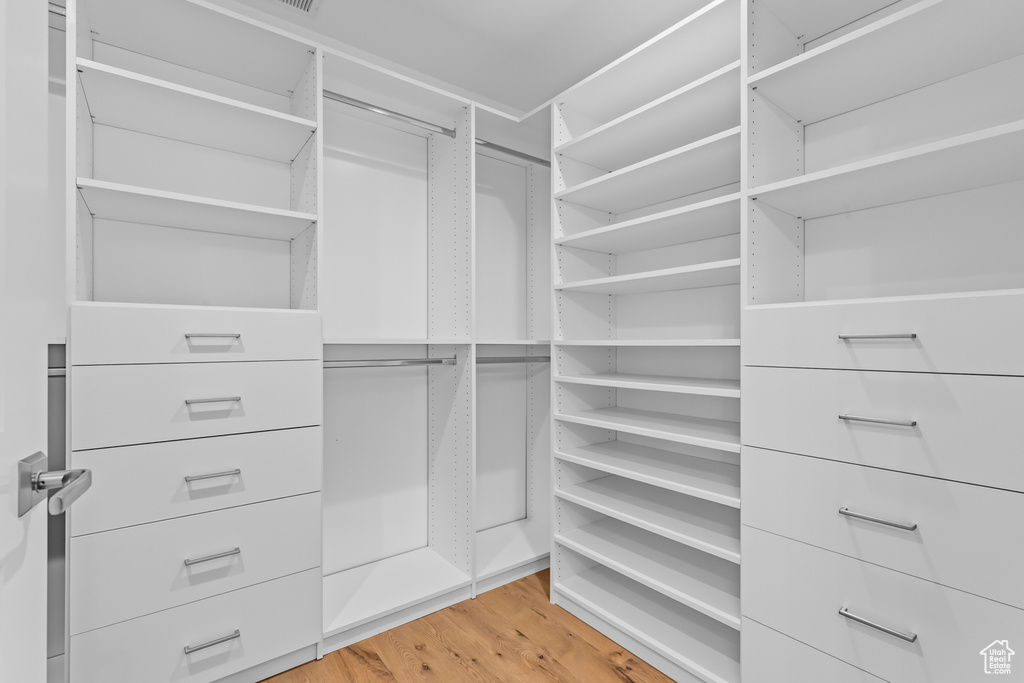 Walk in closet with wood-type flooring