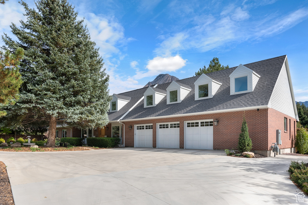 Cape cod-style house featuring a garage