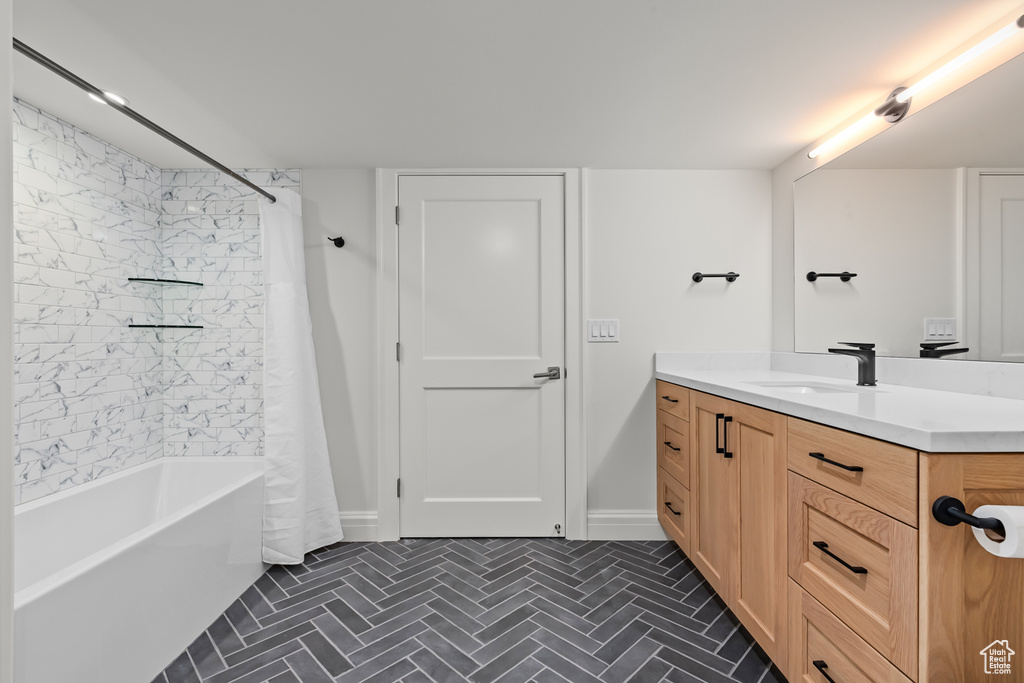 Bathroom featuring vanity, shower / bath combo, and tile patterned flooring