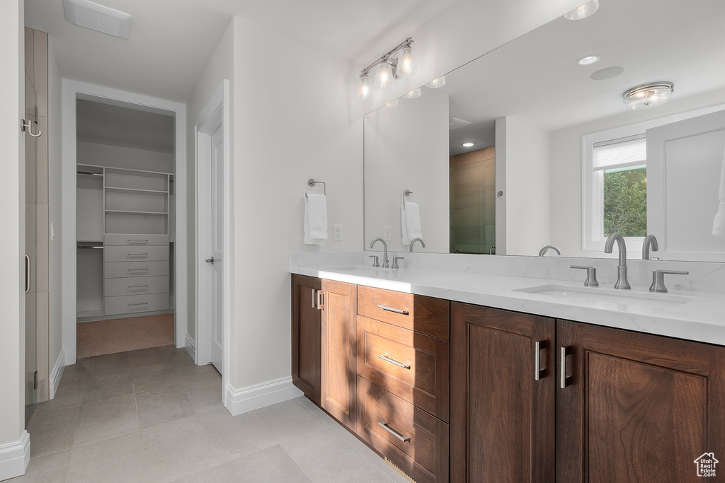 Bathroom with vanity, tile patterned floors, and a shower with shower door