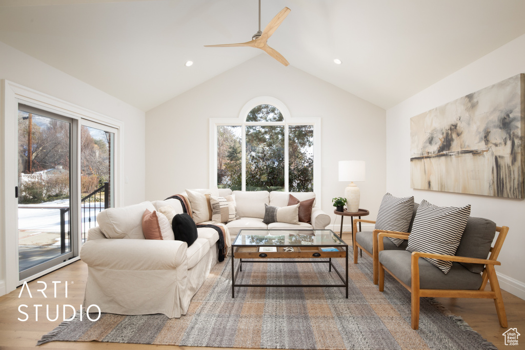 Living room with wood-type flooring, lofted ceiling, and ceiling fan