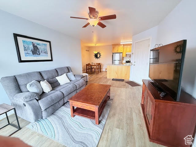 Living room with light hardwood / wood-style flooring and ceiling fan