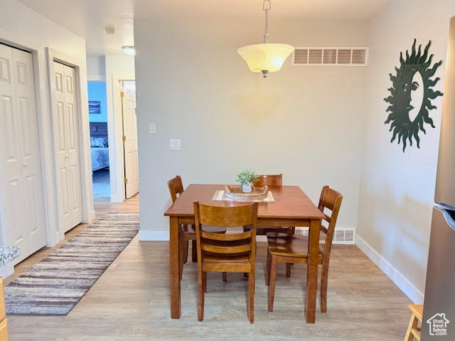 Dining space with light hardwood / wood-style flooring