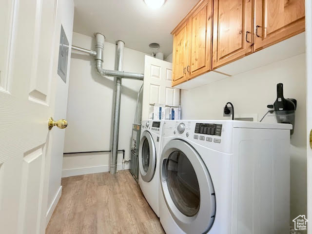 Clothes washing area with independent washer and dryer, light hardwood / wood-style floors, and cabinets