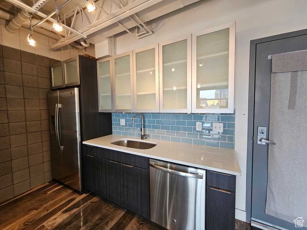 Kitchen featuring backsplash, appliances with stainless steel finishes, sink, and dark hardwood / wood-style flooring