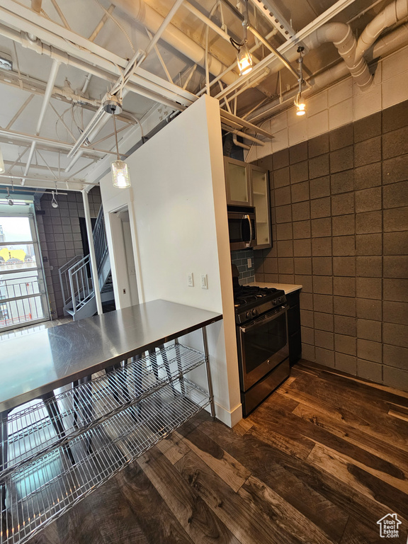 Kitchen featuring dark wood-type flooring and gas stove