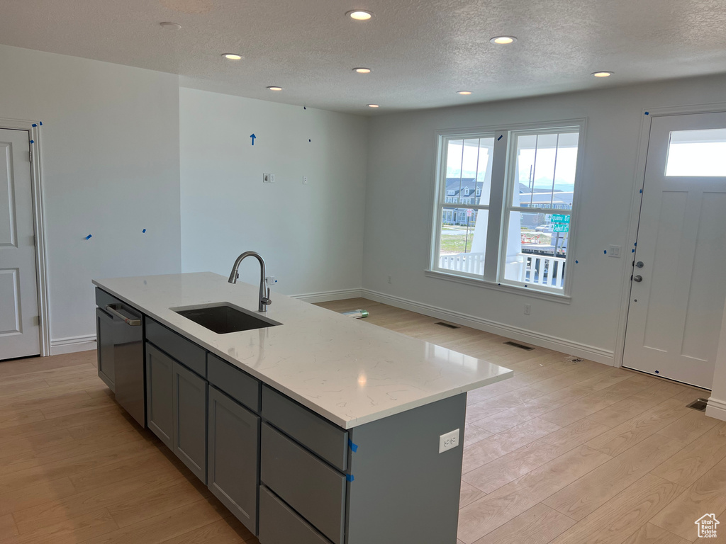 Kitchen featuring dishwasher, a sink, light wood-style floors, recessed lighting, and gray cabinets