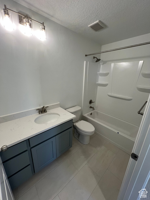 Bathroom with washtub / shower combination, vanity, a textured ceiling, toilet, and visible vents