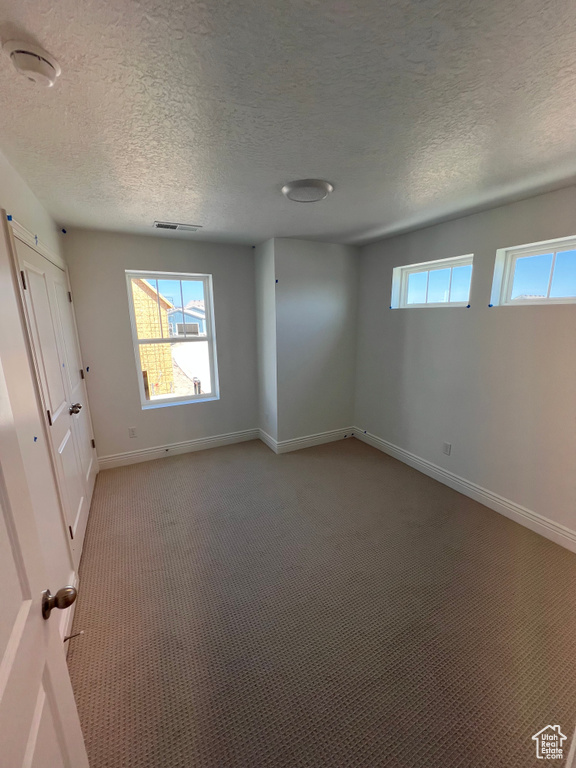 Unfurnished bedroom with visible vents, baseboards, multiple windows, and light carpet