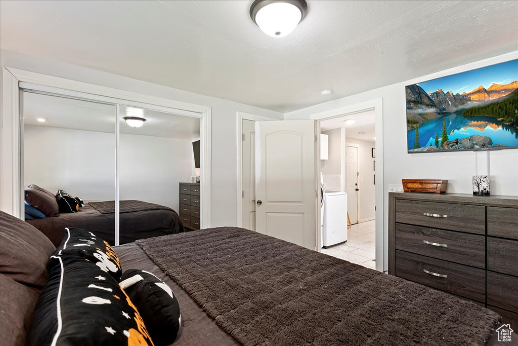 Tiled bedroom with washer / dryer and a closet