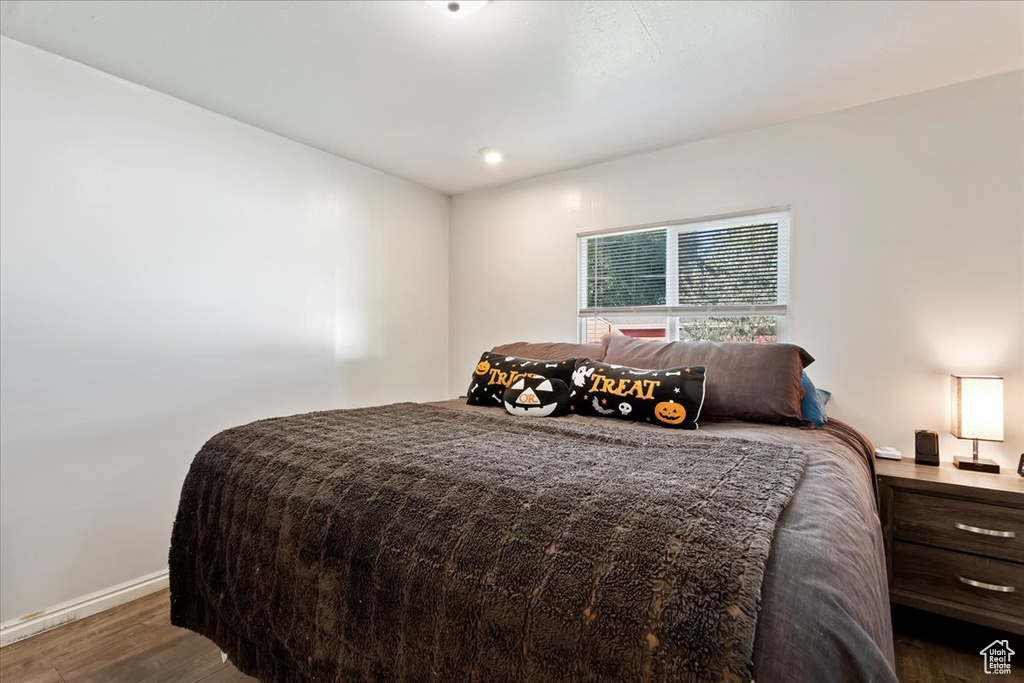 Bedroom with dark hardwood / wood-style flooring