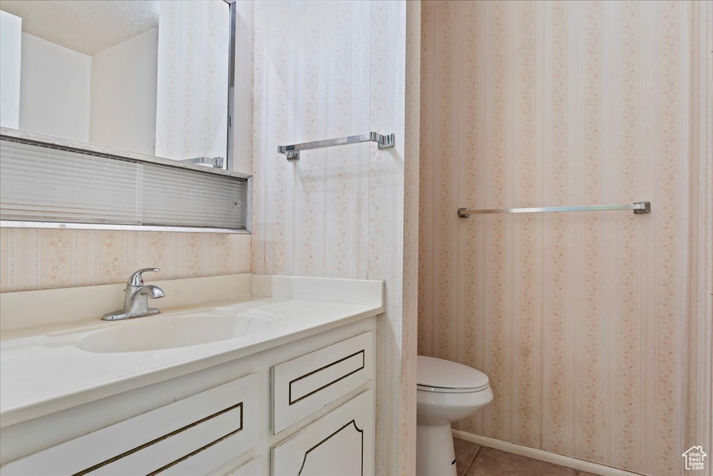 Bathroom with vanity, toilet, and tile patterned flooring